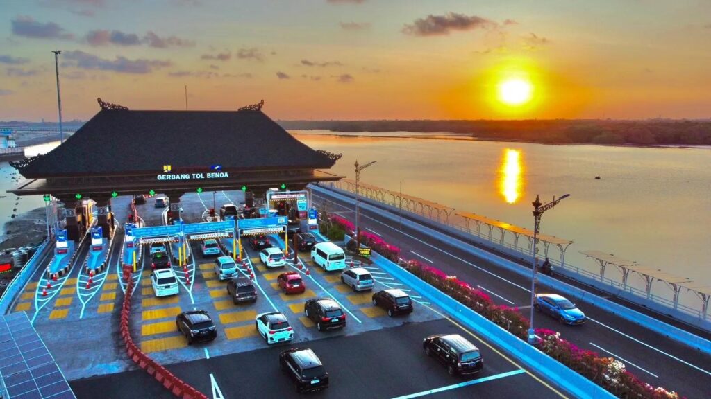"Bali Mandara toll road with cars and sunset view over the sea"
