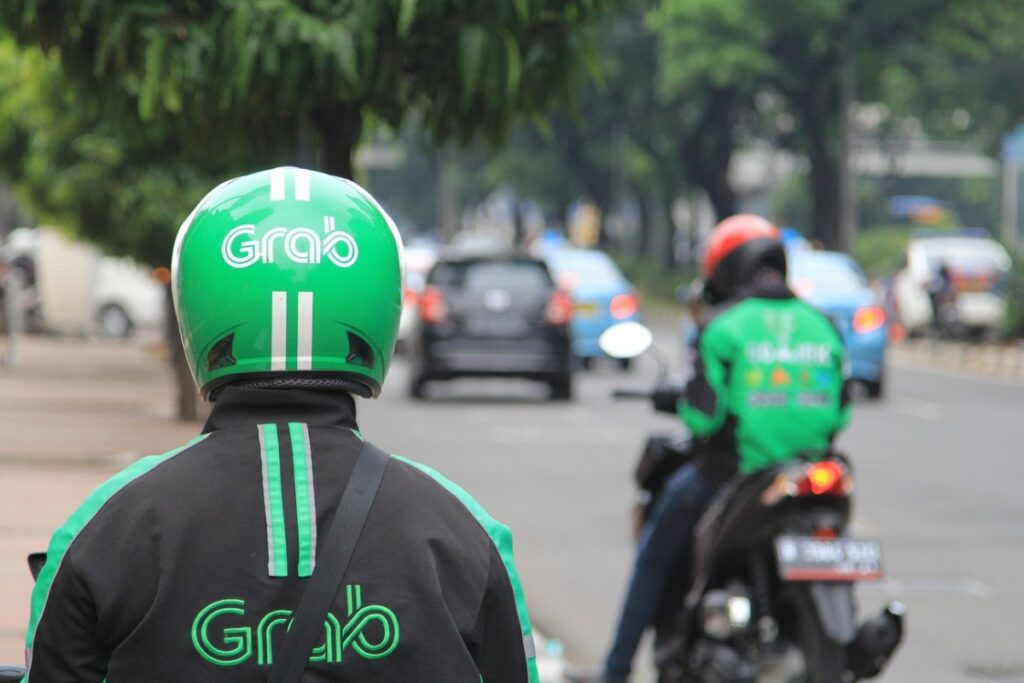 "Grab motorbike riders in Bali wearing green helmets and jackets"