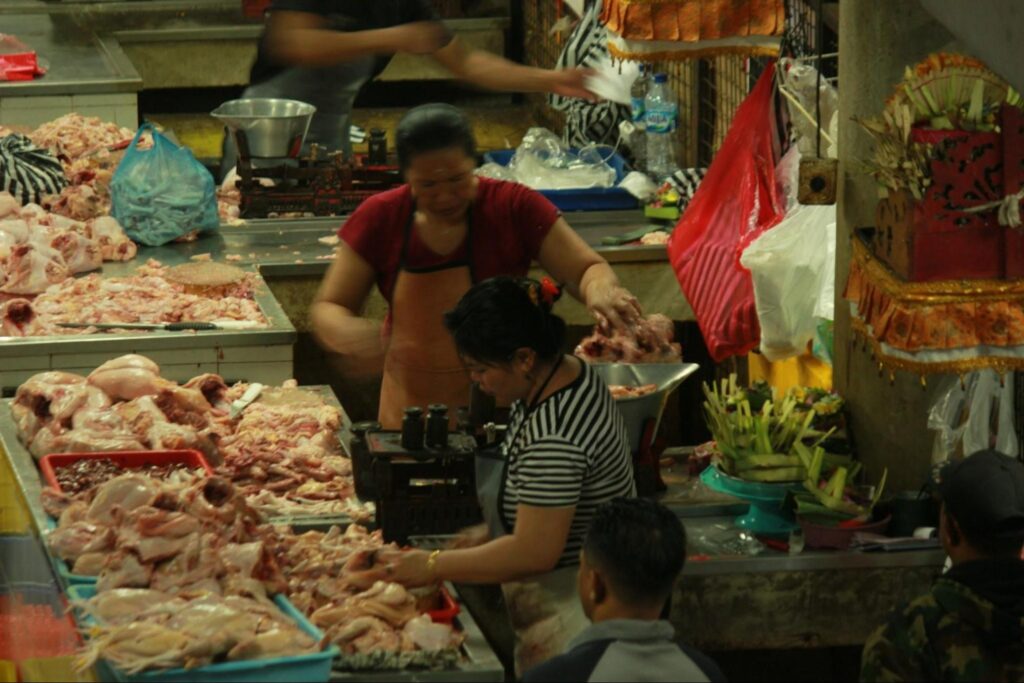 Butchers selling fresh meat at a traditional market in Bali