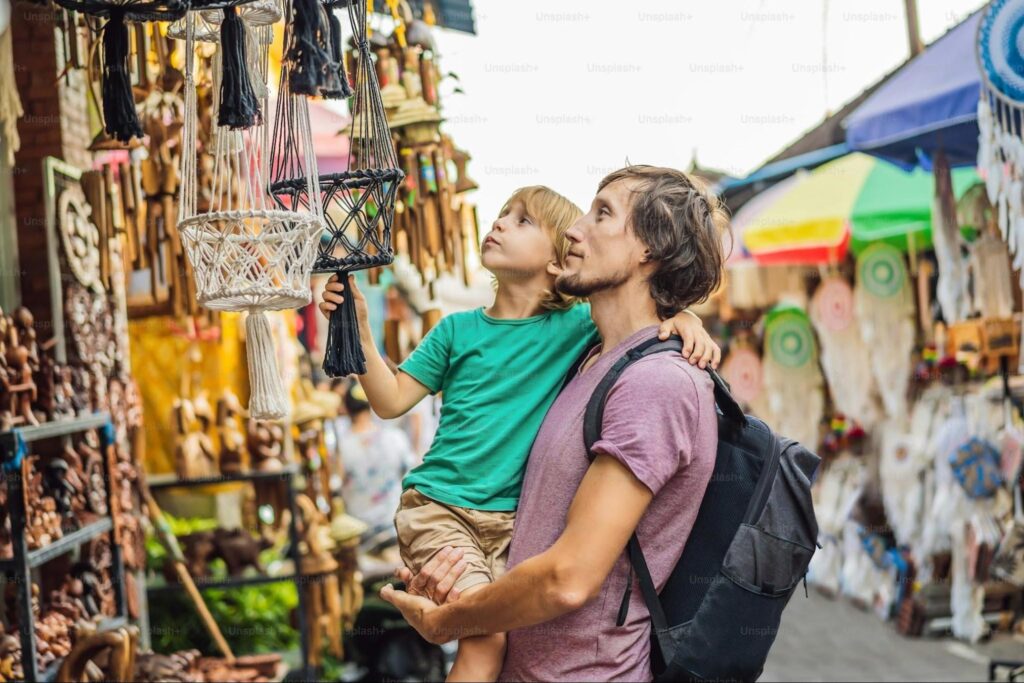 Family browsing handicraft stalls at a Bali art market